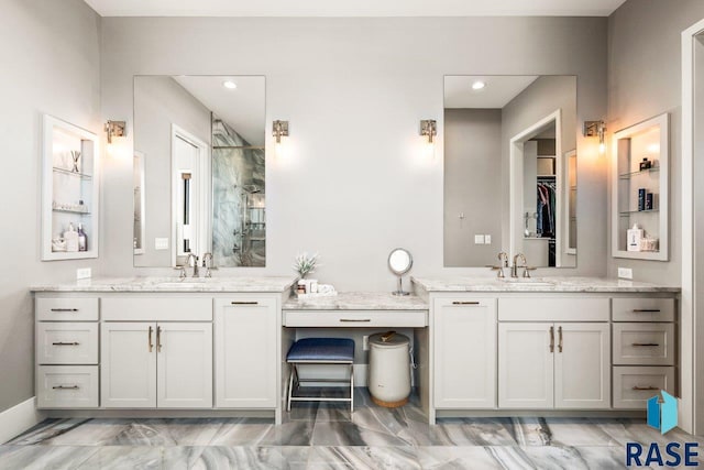 bathroom featuring two vanities, a sink, a marble finish shower, and recessed lighting