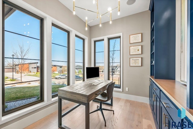 office featuring baseboards, a notable chandelier, and light wood-style flooring