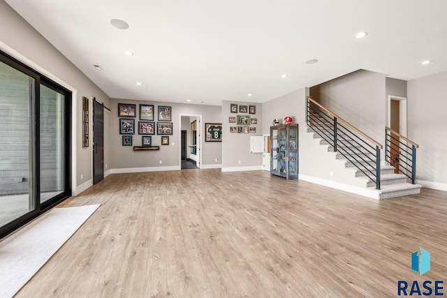 unfurnished living room with stairway, baseboards, light wood-style floors, and recessed lighting