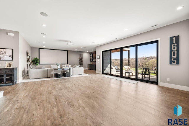 unfurnished living room with recessed lighting, wood finished floors, and baseboards