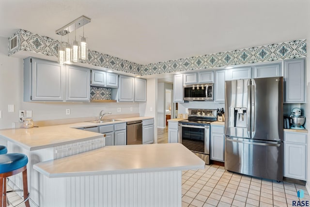 kitchen with stainless steel appliances, a peninsula, a sink, open shelves, and light countertops