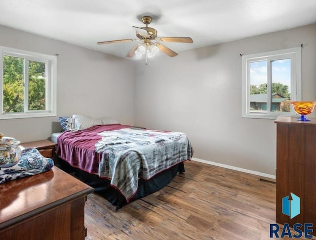 bedroom with baseboards, a ceiling fan, and wood finished floors