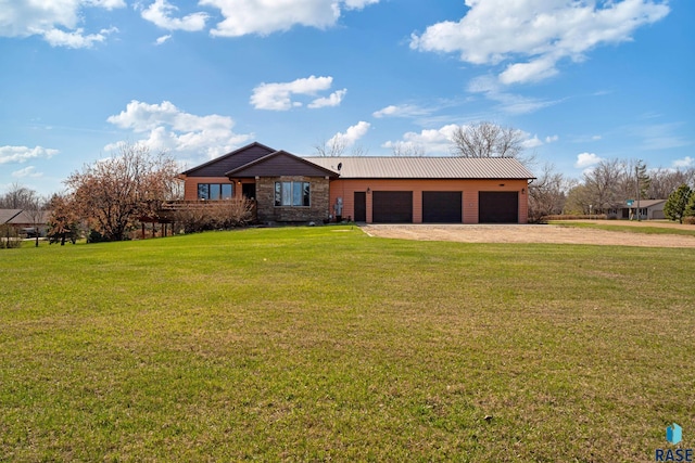 ranch-style home featuring dirt driveway, metal roof, a front yard, and a garage