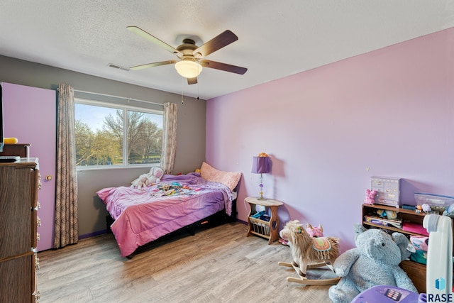 bedroom featuring visible vents, wood finished floors, and ceiling fan