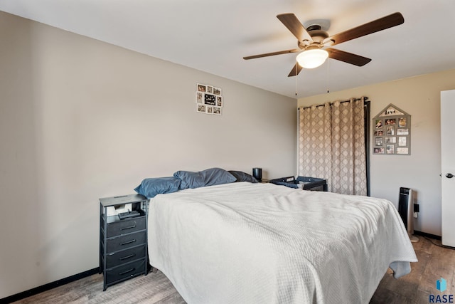 bedroom featuring baseboards, a ceiling fan, and wood finished floors