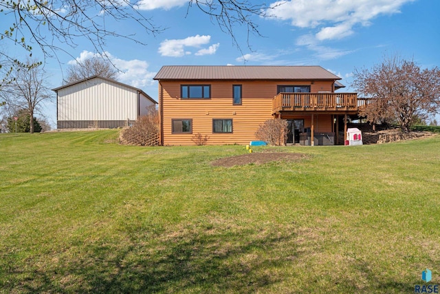 back of property featuring a wooden deck, a yard, and metal roof