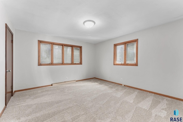 unfurnished bedroom with a baseboard heating unit, baseboards, and carpet