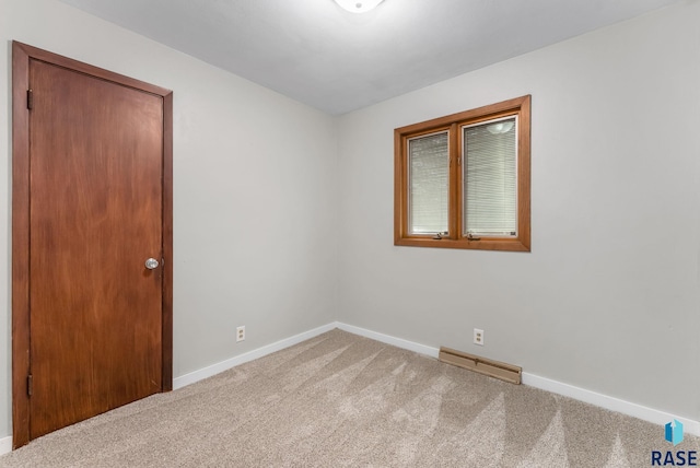 spare room featuring baseboards, visible vents, and carpet