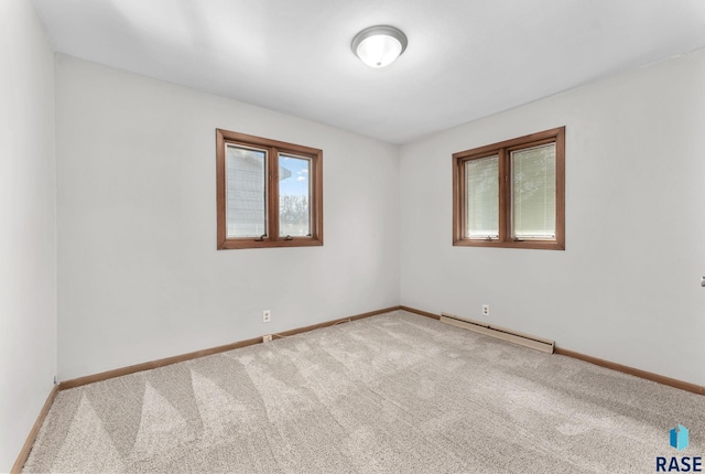 carpeted empty room with baseboard heating and baseboards