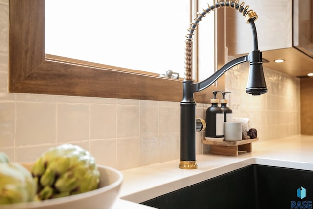interior details featuring tasteful backsplash, a sink, and light countertops
