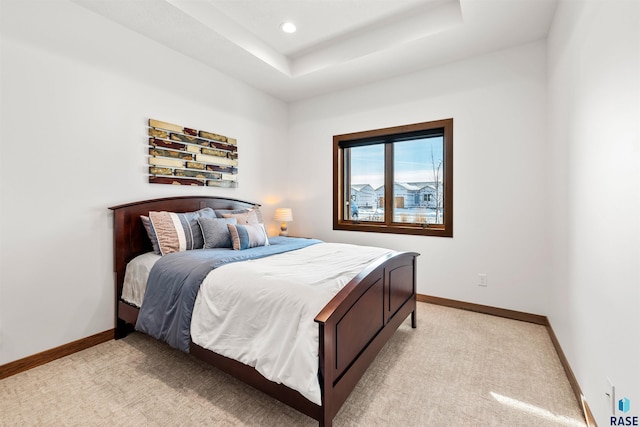 bedroom with a tray ceiling, baseboards, recessed lighting, and light colored carpet