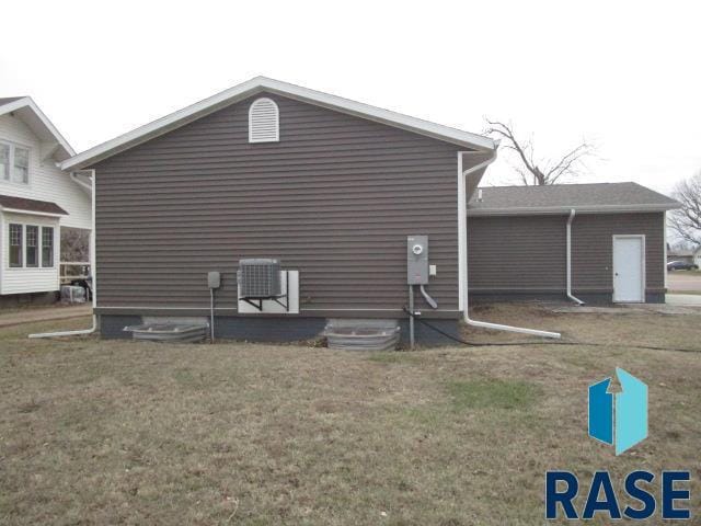 view of home's exterior featuring central AC unit and a yard
