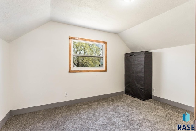 bonus room with vaulted ceiling, baseboards, carpet floors, and a textured ceiling