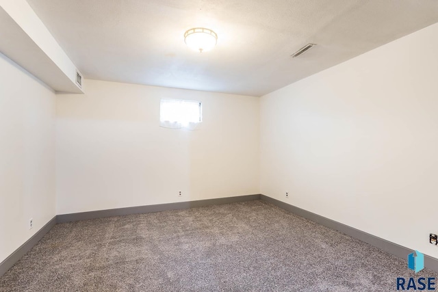 carpeted empty room featuring visible vents and baseboards