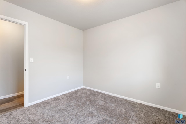 spare room featuring carpet flooring and baseboards
