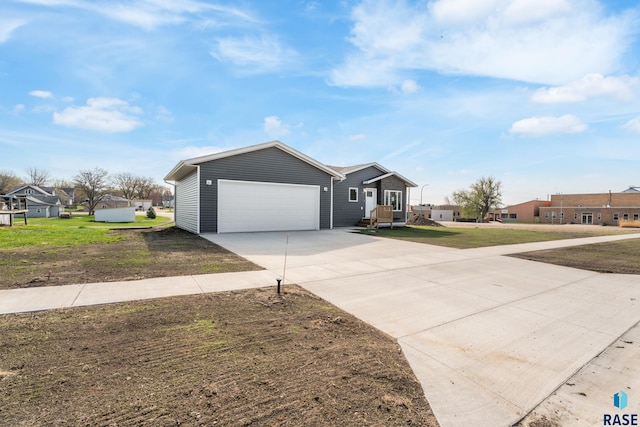 ranch-style house featuring a garage, a front yard, a residential view, and concrete driveway