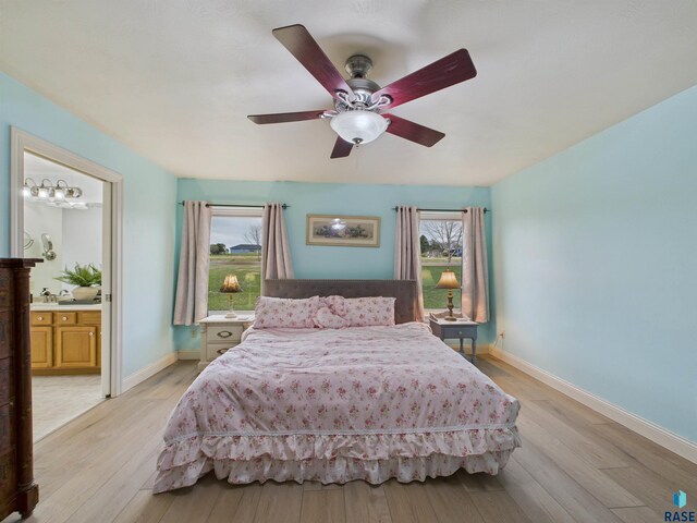bedroom with ensuite bath, baseboards, ceiling fan, and light wood-type flooring