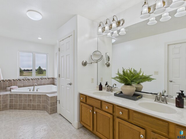 full bathroom with double vanity, a garden tub, tile patterned floors, and a sink