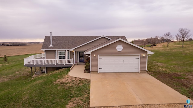 view of front of property with a front yard, a deck, a garage, and concrete driveway