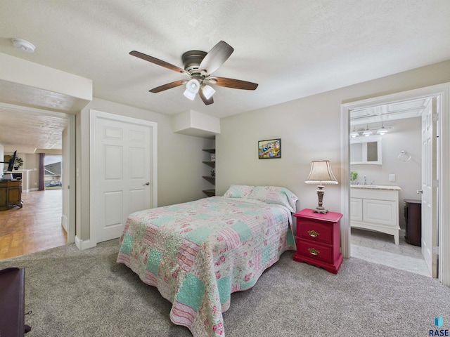bedroom with ensuite bath, a ceiling fan, and carpet flooring