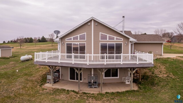 rear view of property with a patio, a wooden deck, and a yard