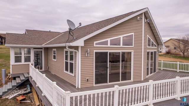 back of property with a deck and a shingled roof