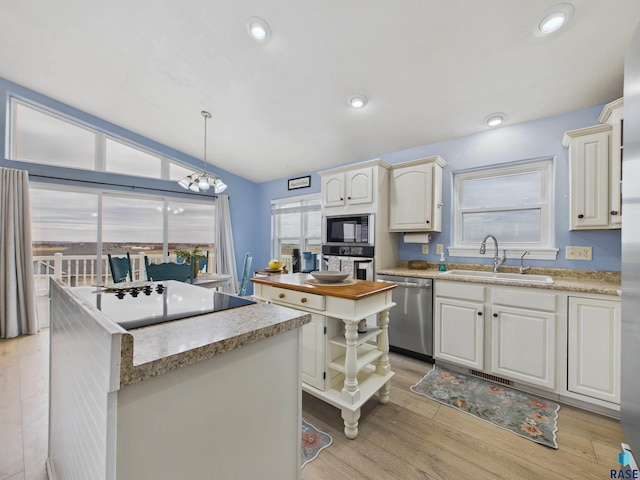 kitchen with a sink, a chandelier, stainless steel appliances, open shelves, and light wood-style flooring