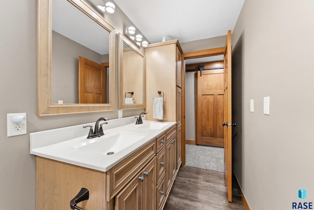 501 Taylor Dr, Tea, SD 57064 - bathroom with baseboards, wood finished floors, double vanity, and a sink