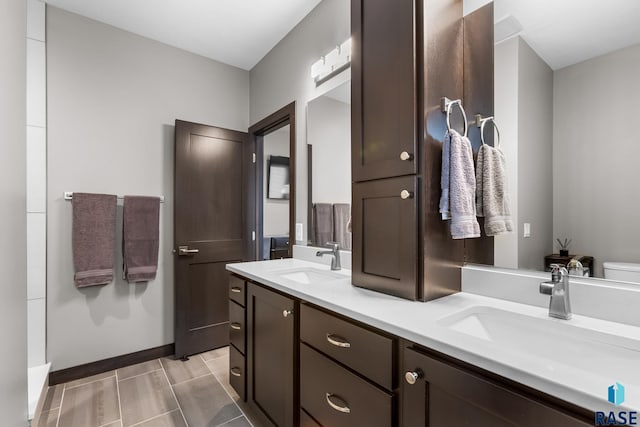 1917 S Firefly Dr, Sioux Falls, SD 57110 - full bathroom with toilet, double vanity, a sink, and baseboards