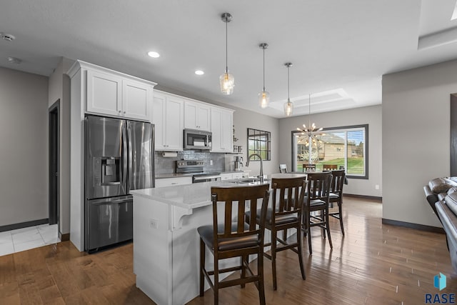 1917 S Firefly Dr, Sioux Falls, SD 57110 - kitchen with a kitchen island with sink, a chandelier, stainless steel appliances, a sink, and baseboards