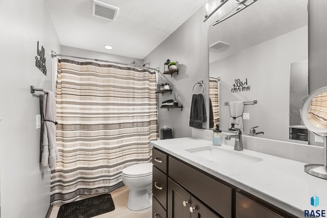 1917 S Firefly Dr, Sioux Falls, SD 57110 - bathroom with a textured ceiling, visible vents, toilet, vanity, and tile patterned flooring