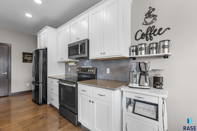 1917 S Firefly Dr, Sioux Falls, SD 57110 - kitchen featuring backsplash, appliances with stainless steel finishes, wood finished floors, and white cabinetry