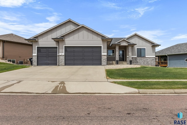 1917 S Firefly Dr, Sioux Falls, SD 57110 - view of front facade featuring board and batten siding, stone siding, a front yard, concrete driveway, and an attached garage