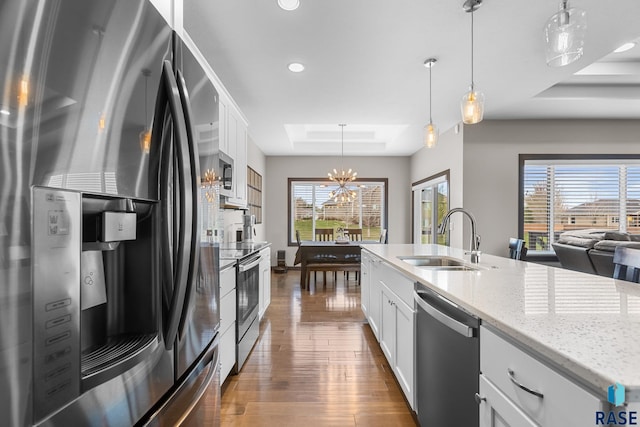 1917 S Firefly Dr, Sioux Falls, SD 57110 - kitchen featuring white cabinets, a sink, appliances with stainless steel finishes, a tray ceiling, and a notable chandelier