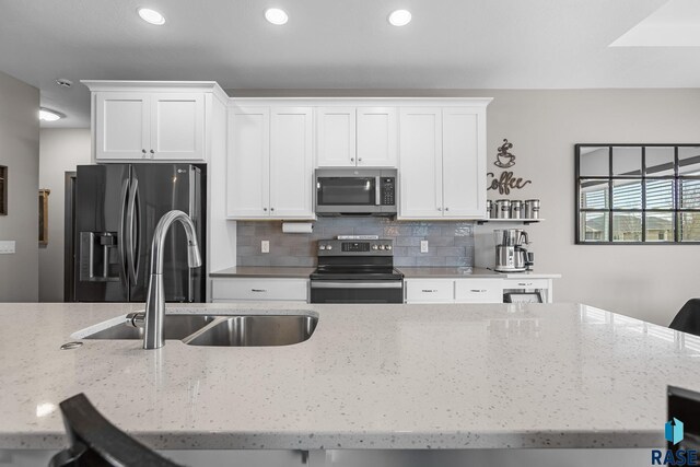 1917 S Firefly Dr, Sioux Falls, SD 57110 - kitchen with backsplash, a sink, white cabinetry, and stainless steel appliances