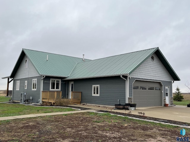 view of front of home featuring a garage, metal roof, and concrete driveway