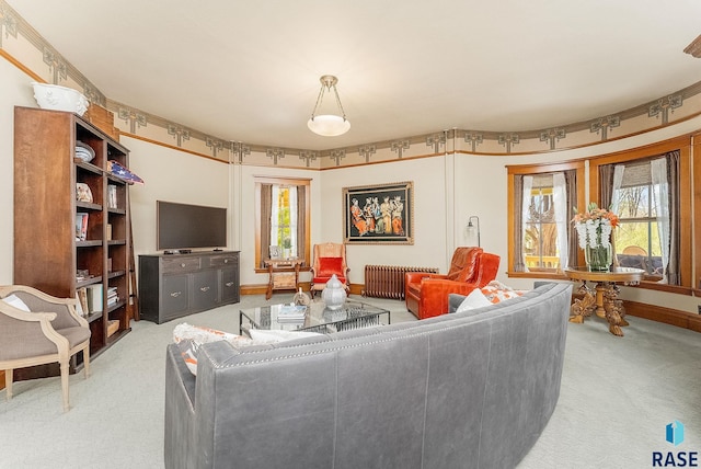 carpeted living room with radiator heating unit and baseboards
