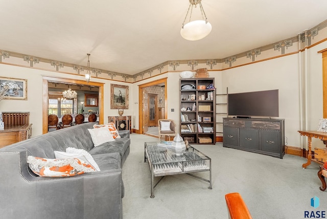 carpeted living area featuring a notable chandelier and baseboards