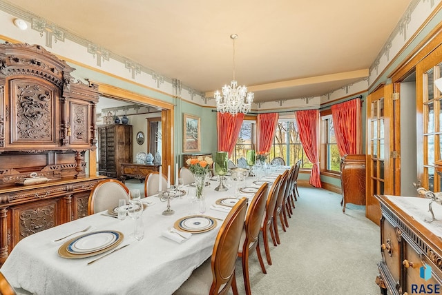 dining area with an inviting chandelier and light colored carpet
