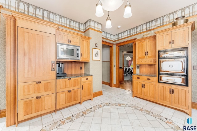 kitchen featuring stainless steel microwave, dark stone counters, a warming drawer, baseboards, and wall oven
