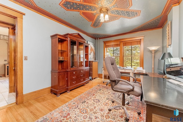 home office with baseboards, ceiling fan, light wood-style floors, and crown molding