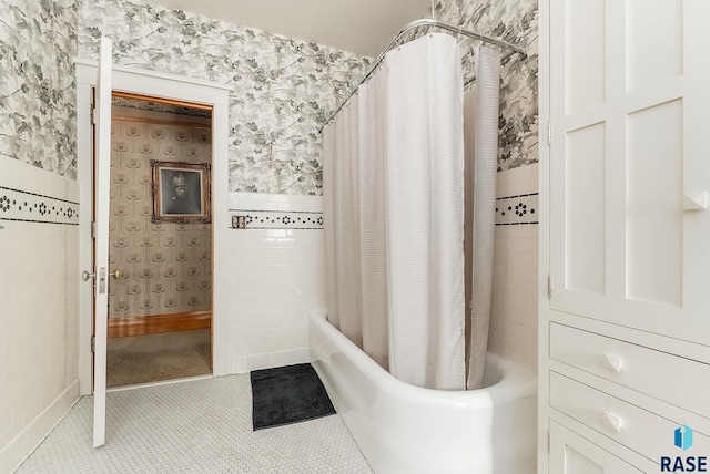 bathroom featuring shower / bathtub combination with curtain, wallpapered walls, and tile patterned flooring