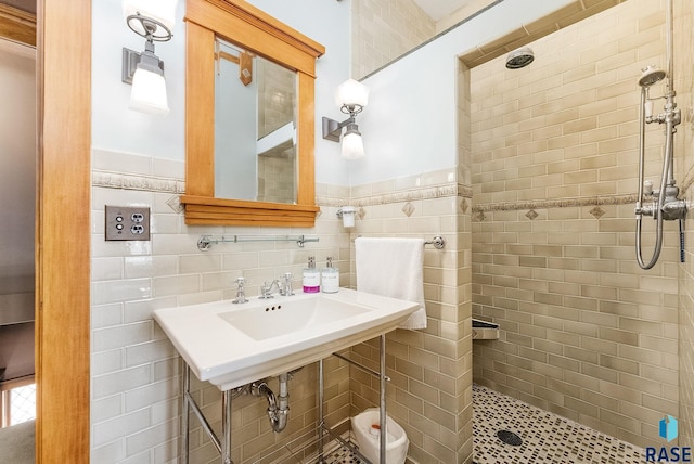 full bathroom featuring tile walls, wainscoting, and tiled shower