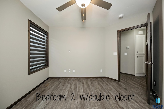 empty room featuring wood finished floors, a ceiling fan, and baseboards