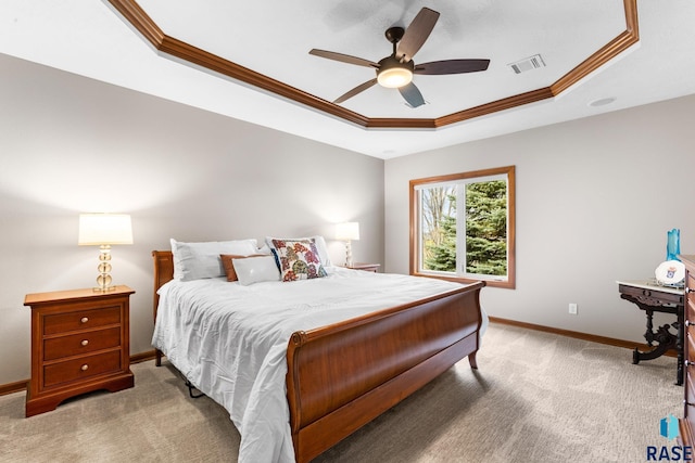 bedroom featuring baseboards, visible vents, ornamental molding, and a tray ceiling