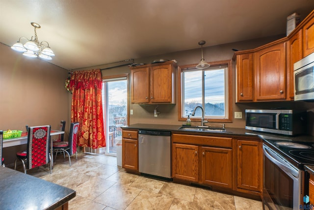 kitchen featuring an inviting chandelier, a healthy amount of sunlight, stainless steel appliances, and a sink