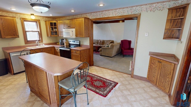712 6th St, Brookings, SD 57006 - kitchen featuring brown cabinets, a sink, a kitchen island, appliances with stainless steel finishes, and light floors