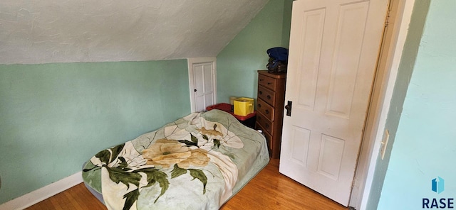 712 6th St, Brookings, SD 57006 - bedroom with lofted ceiling, wood finished floors, and baseboards