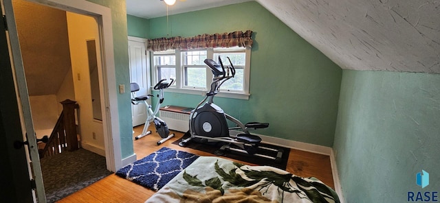 712 6th St, Brookings, SD 57006 - workout area featuring radiator heating unit, vaulted ceiling, wood finished floors, and baseboards