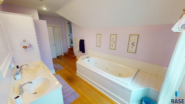712 6th St, Brookings, SD 57006 - full bathroom with a sink, wood finished floors, double vanity, a jetted tub, and lofted ceiling